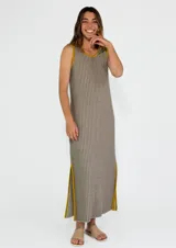 Vestido largo a rayas verticales color gris y blanco, con cuello en V y ribete amarillo. Presenta aberturas laterales con ribete amarillo.