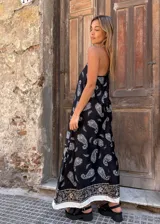 Vestido largo negro con estampado de cachemir en blanco y beige. Tiene breteles finos y corte amplio.