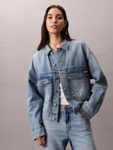 Campera de denim Calvin Klein en tono azul lavado, con corte relajado, cierre frontal con botones metálicos y doble bolsillo frontal con solapa.