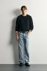Pantalón jeans de corte recto, color celeste claro con efecto lavado, de cinco bolsillos y tiro medio.