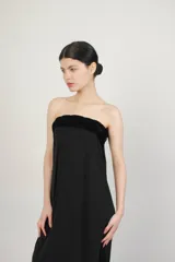 Falda larga negra con tajo lateral y pretina con trenza de terciopelo.