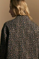 Sobrecamisa de corte relajado con estampado animal print, cuello camisero, cierre frontal con botones y bolsillos aplicados.