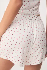 Pijama de viscosa y elastano de color blanco con estampado de fresas, compuesto por una remera de manga corta y cuello redondo, y un short con cintura elástica.