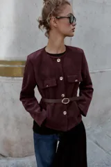 Blazer de cuello redondo y manga larga, confeccionado en tejido efecto ante. Presenta cierre frontal con botones, bolsillos con tapeta en el pecho y cinturón ajustable en la cintura.