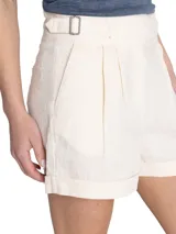 Short de tiro alto color crudo, confeccionado en lino orgánico, con cierre cruzado, hebillas en los costados, bolsillos y pinzas.