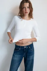 Camiseta blanca de manga larga con cuello panadero y cierre frontal de botones, corte slim fit.