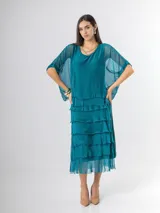 Vestido midi de seda italiana color negro, diseño dos en uno con capa superior de calce amplio, falda con volados y forro interior de algodón elastizado.