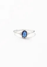 Anillo de plata 925 con zirconia azul marino ovalada y pequeñas zirconias blancas a los lados.