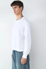 Camiseta de manga larga con corte boxy y cuello redondo, confeccionada en 100% algodón. Presenta una silueta holgada y diseño minimalista.