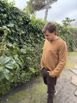 Sweater azul marino de lana con cuello redondo y logo bordado en rojo en el pecho. Corte holgado.