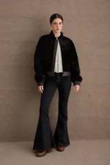 Campera tipo bomber de textura afelpada en color negro, con cierre frontal, cuello alto y puños y ruedo elásticos en cuero.