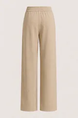 Pantalón de punto color beige, de corte recto y holgado, con cintura elástica y cordón ajustable.