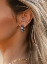 Aros tipo argolla de acero con incrustaciones de circonias blancas y piedras azules en formato rectangular.