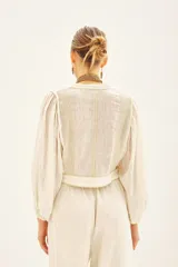 Camisa corta de corte regular, confeccionada en algodón con hilos de lurex. Mangas amplias con elástico interno.