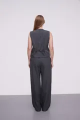 Pantalón de vestir gris oscuro con finas rayas verticales blancas, corte palazzo y bolsillos laterales.