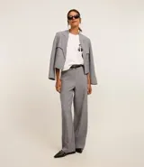 Blusa blanca de algodón con cuello redondo y mangas cortas. Presenta un estampado de una caricatura de una mujer con boina, lentes de sol y un trago en la mano.