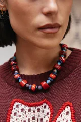 Collar corto compuesto por una combinación de piedras reconstituidas, piedras naturales y cristales checos en tonos rojos, azules y celestes. Cuenta con cierre de cadena de acero quirúrgico ajustable.