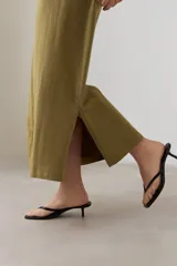 Vestido largo verde oliva con cuello en V, mangas cortas y costuras verticales.