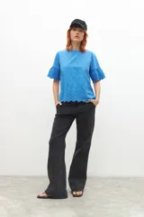Remera celeste con broderie, de mangas cortas con volados.