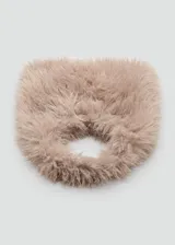 Bolso de mano con diseño triangular y textura de pelo sintético en color beige. Cuenta con un detalle de aro metálico circular en la parte frontal y asa integrada para llevar al hombro.