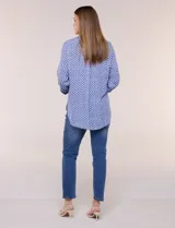 Camisa azul con estampa geométrica, de corte clásico y calce relajado, con cuello camisero tradicional, cierre frontal de botones y mangas largas con presillas para arremangar.