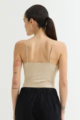 Body color beige con breteles finos.