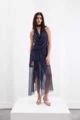 Falda midi azul marino con estampado de lunares blancos, confeccionada con una base mini y capas superpuestas de tul translúcido con diseño irregular.