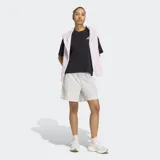 Short de running Adidas de corte holgado, color gris claro, con bolsillos laterales amplios y logo de la marca en el bajo. Cuenta con cintura elástica y cordón de ajuste.