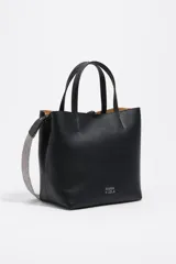 Bolso de hombro estructurado de piel vacuna negra, con doble asa de mano y asa regulable de tejido a rayas. Presenta cierre de cordón, logo metálico frontal y bolsillo interior con cierre de cremallera.