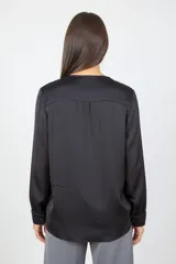 Blusa de satén color negro, con escote en V y mangas largas con puños. Presenta un diseño de corte relajado y acabado brillante.