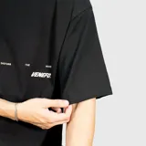 Remera negra de corte oversize con estampa gráfica en la espalda en color crema que incluye el texto 'WE ARE VENEFO' y una frase secundaria. Confeccionada en algodón de alta calidad.