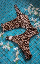 Conjunto de bikini con estampado animal print, compuesto por un corpiño de triángulo con breteles finos y una bombacha cavada con detalle de aro dorado en la cintura.