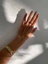 Anillo abierto de diseño orgánico con textura irregular y acabado brillante, realizado artesanalmente en metal.