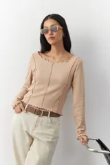 Remera blanca de manga larga con cuello redondo y costuras a la vista.