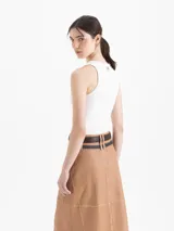 Top negro de tejido frío, ajustado al cuerpo y largo por debajo de la cintura.