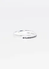 Anillo de plata 925 con diseño de banda fina decorada con una hilera central de zirconias negras y bordes con zirconias blancas.