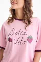 Remera de algodón rosada con diseño oversize y mangas cortas de corte loose fit. Presenta un estampado frontal con la frase "Dolce Vita" y dibujos de fresas, además de ribetes en contraste de tono oscuro en el cuello y los puños.