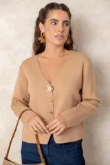 Cardigan de punto fino color negro con escote en V, manga larga y cierre frontal con botones dorados labrados, destacando un botón joya superior en forma de flor.