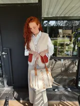 Bolso tipo tote de cuero color crudo con costuras decorativas en hilo color cuero. Tiene doble asa de cuero color cuero y forro interior de tela.