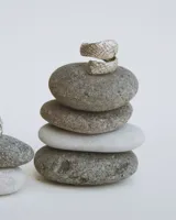 Anillo de diseño abierto con textura escamada que simula la piel de una serpiente, elaborado artesanalmente en metales nobles.