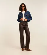 Campera regular de jean azul, con cuello camisero de cuerina marrón, bolsillos frontales con solapa y botones dorados.