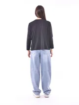 Remera de manga larga color beige, con cuello redondo y estampado frontal que dice "Magic is something you make" en color lila.