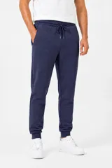 Pantalón de jogging de felpa en color azul marino, con cintura elástica ajustable mediante cordón y puños acanalados en los tobillos. Cuenta con bolsillos laterales.