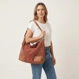 Bolso de eco cuero con textura símil gamuza en color marrón terracota, con detalles de refuerzo en eco cuero liso color tostado en las esquinas inferiores y asas. Cuenta con gran capacidad, ideal para uso diario.