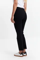 Jean straight de tiro medio, color azul denim, con corte recto y ruedo desflecado.