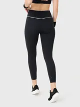 Calza deportiva de largo ankle en color negro, con cintura alta que presenta un detalle de líneas blancas en el borde superior.