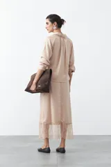 Falda midi negra de caída fluida con cintura elastizada y un amplio detalle de encaje negro en el bajo.