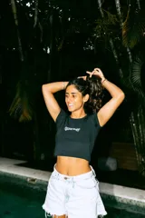 Top negro corto con estampado frontal de la marca "Glassy Waves".