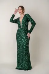 Vestido largo de fiesta color verde esmeralda con lentejuelas, escote en V con tul y apliques de strass en escote y cintura. Mangas largas y corte ajustado.