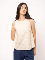 Top de lino color crema, sin mangas, con escote redondo y bordados florales.